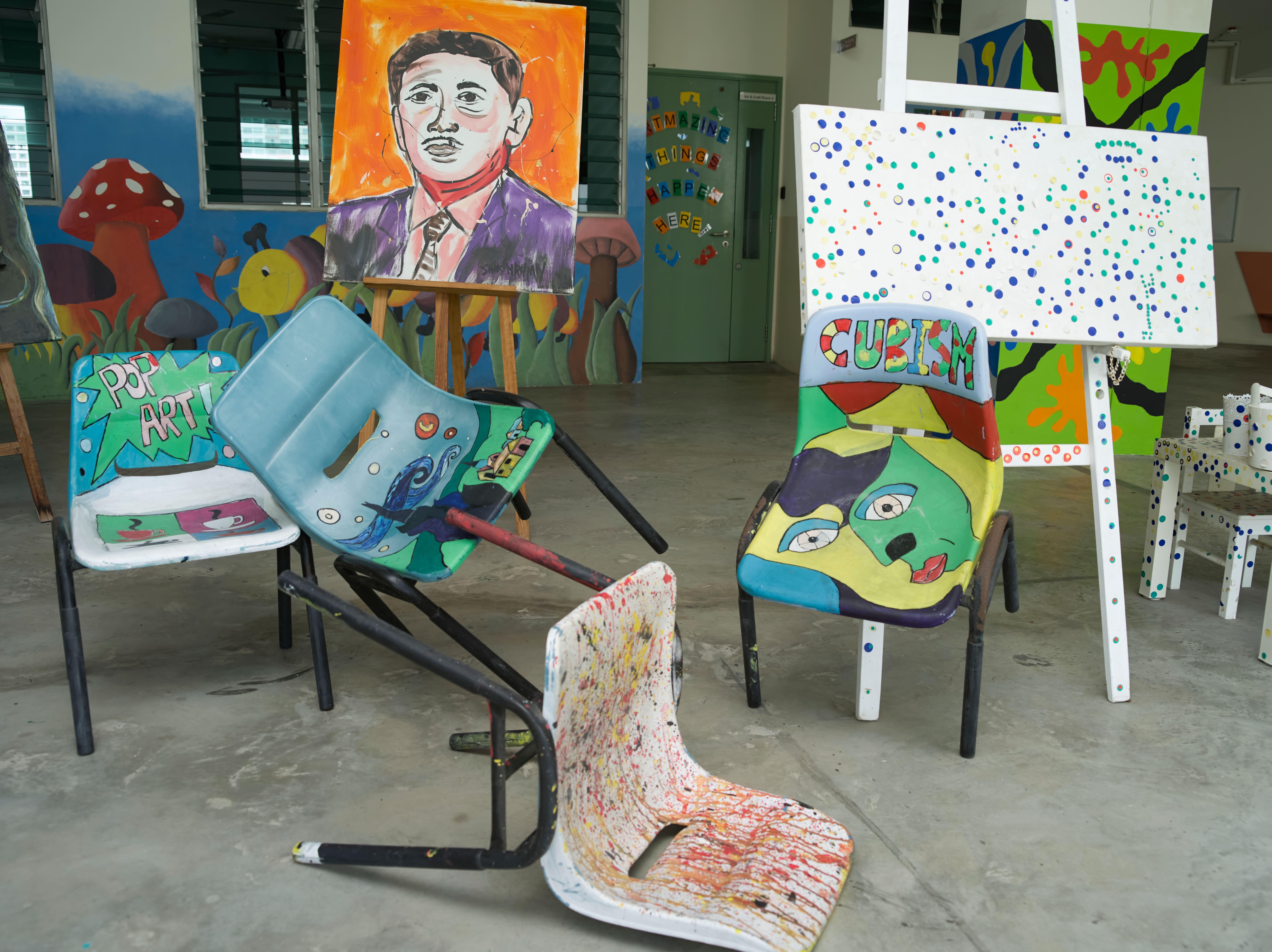 Colourful student artworks and painted furniture displayed outside the art room.